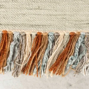 Detailaufnahme der Fransen des Teppich Saigon 160x230 in Orange mit gewebtem Muster aus recyceltem Polyester.